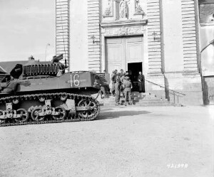 Soldats américains, près de leur tank, discutant avec deux ecclésiastiques aux portes de l'église de Trinité à Château-Gontier.